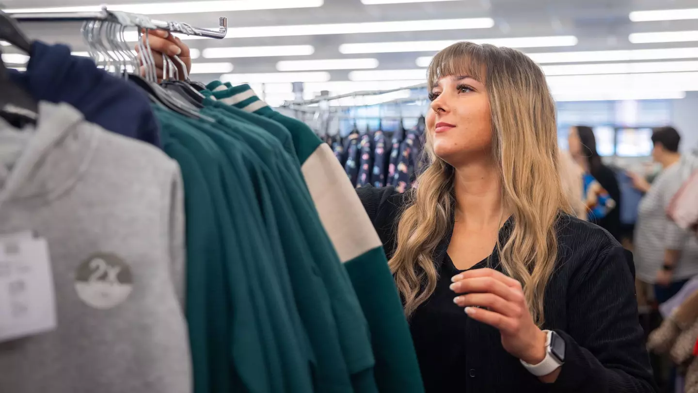 Eine Frau hängt Kleidung an einen Kleiderhaken