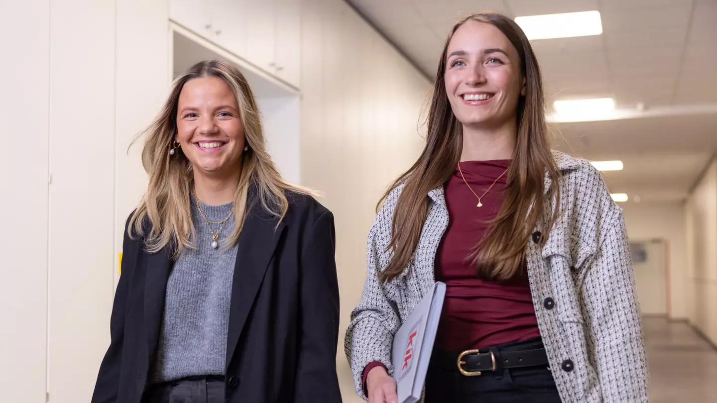 Zwei Mitarbeiterinnen laufen lächelnd über den Flur der KiK Zentrale