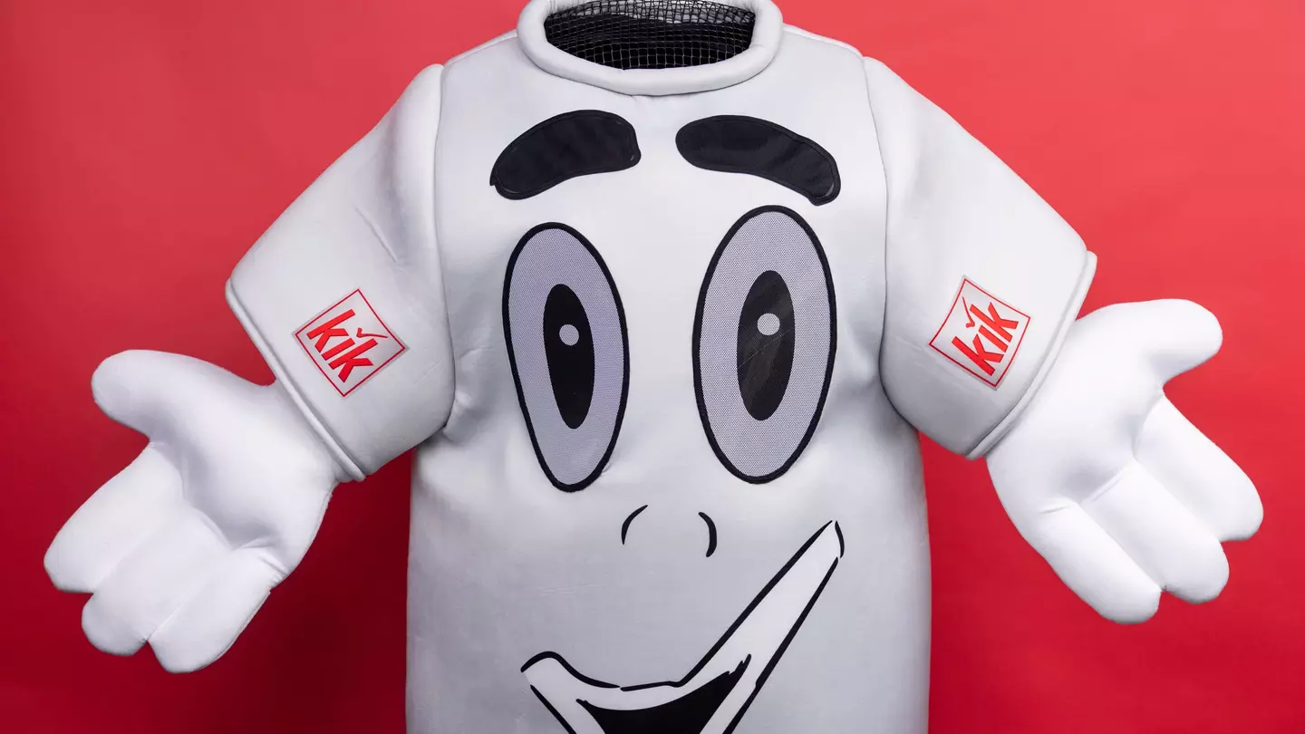 Das KiK-Tshirt mit ausgebreiteten Armen lächelt freundlich in die Kamera