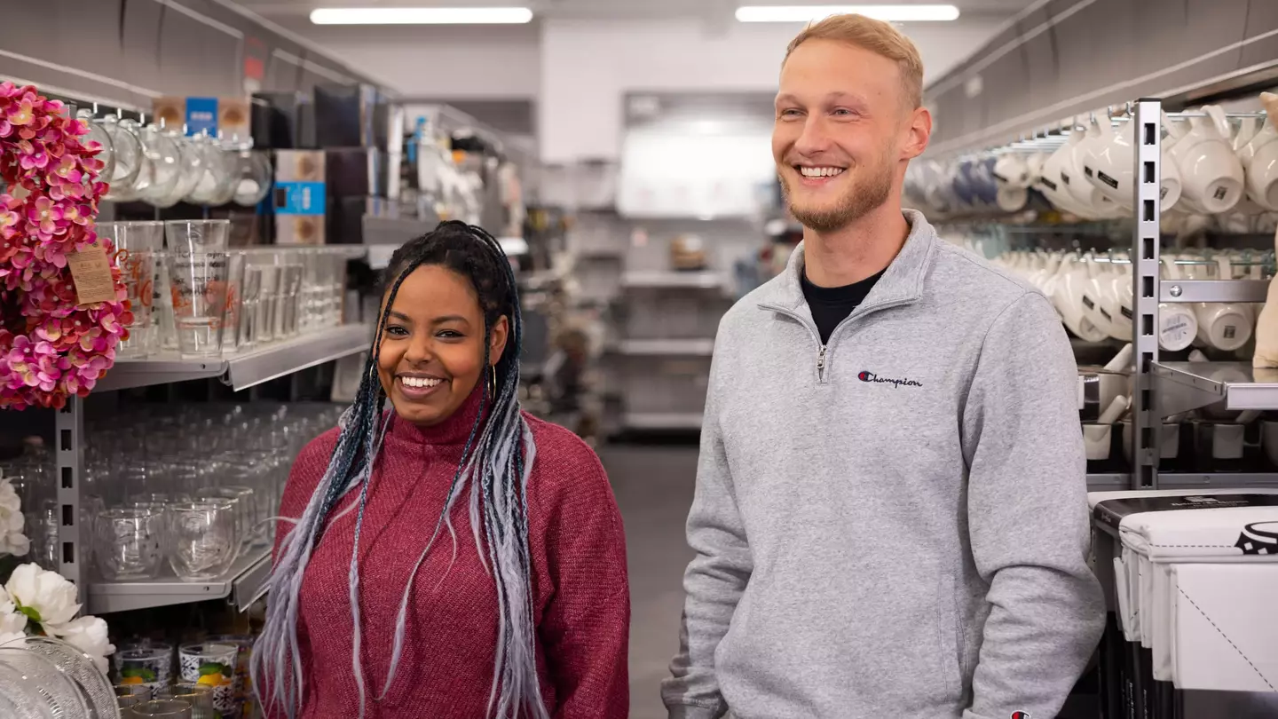 Ein Mann und eine Frau stehen in einer modernen Filiale und lächeln